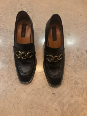 Svarta loafers med klack från Novita - 37 - Stilrena svarta loafers från Novita. Sparsamt använda. Nypris var runt 2000kr. Storleken är 37.