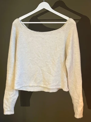 Ljusbeige stickad tröja - Säljer en ljusbeige  stickad tröja med bred urringning och långa ärmar. Tröjan har en enkel och stilren design, perfekt att matcha med höga jeans eller kjol. Materialet känns mjukt och lätt, vilket gör den skön att bära. Köpt från Monki🤎