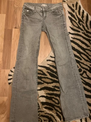 Grå bootcut jeans från gina young - Snygga grå jeans från gina med klassisk femficksdesign och bootcut passform. Jeansen har normal midja och är tillverkade i mjukt denimtyg. Perfekta för dig som gillar en avslappnad men ändå stilren look. Storlek 158
