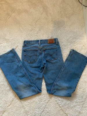 Levi's lågmidjade bootcut jeans - Säljer ett par blåa lågmidjade bootcut jeans från Levi’s. Storleken är 25 i midian. De är att par jättefina jeans men tuvärr alldeles för stora på mig (kan därför inte visa bild på). Inga defekter. 