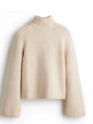Beige stickad polotröja - Mysig beige stickad tröja med hög krage och raka, långa ärmar. Tröjan har en croppad passform och ribbad kant vid halsen. Perfekt för lager på lager och enkel att styla till olika outfits.