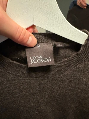 Brun stickad tröja Oscar Jacobson - Mjuk och stilren brun stickad tröja från Oscar Jacobson. Klassisk rund halsringning och långa ärmar. Nypris 1100 kr. Den har krymt väldigt mycket så den passar xs-S