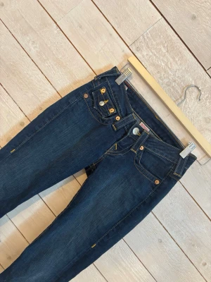 True religion jeans💗💗 - Ett par mörkblåa True religion Jeans med snygga fickor där bak! Det är i storlek 23,men det är uppsydda satt det passar perfekt mig som är 165 men är inte avklippta så går enkelt att ta ner dom igen satt det passar nån som är 170 kanske. Det sitter inte super bootcut men det är endån bootcut,väldigt lowwaist! Gylfen på byxorna är tyvärr inte kvar men det är inget som syns,som man kan se på bilder. Och det påverkar inget dåligt alls,men bara satt man är medveten om det. Skriv privat om mer info😇