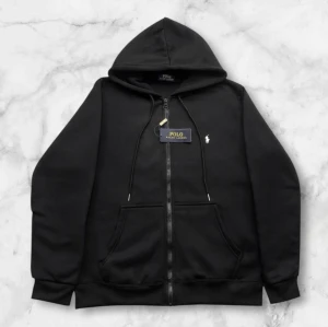 Polo Ralph lauren hoodie  - Svart Polo Ralph Lauren Hoodie  Klassisk svart hoodie med tidlös design 🔥 Mjukt och bekvämt material som sitter skönt hela dagen 🙌 Plagget är aldrig använt och i nyskick 🧥 Passar perfekt till både vardag och mer uppklädda outfits 💯  🔹 Märke: Polo Ralph Lauren 🔹 Färg: Svart 🔹 Skick: Aldrig använt 🔹 Passform: Klassisk 📦 Snabb leverans