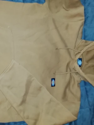 Beige hoodie från Dickies - Säljer en beige hoodie från Dickies i storlek Small. Hoodien har en klassisk huva med dragsko, magficka och mjukt fleecefoder på insidan. Perfekt för dig som gillar streetwear och enkel stil. Dickies-logga finns både på bröstet och i nacken.