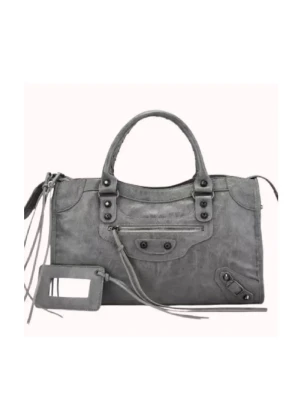 Grå handväska med dragkedja - Snygg grå handväska i skinn med coola metalldetaljer och dragkedja framtill. Väskan har dubbla handtag och medföljande axelrem, perfekt för dig som vill ha både stil och funktion. Rymmer allt du behöver till vardagen och har en modern, lite rockig look. Måtten är 22*40 aldrig använd!