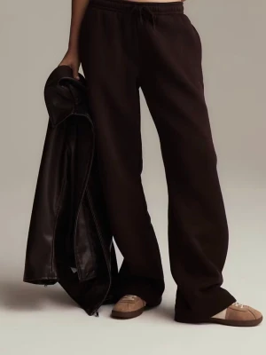 Bruna mjukisbyxor med loose fit - Mörkbruna mjukisbyxor med avslappnad loose passform och resår i midjan med snörning. Tillverkade i mjukt bomullsmaterial, perfekta för chill dagar. Matcha med sneakers eller hoodie för en casual look. Helt ny med prislappen 