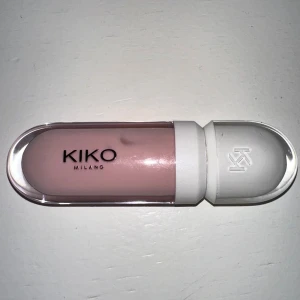 KIKO Milano Lip Volume Tutu Rose - Plumping lip cream i färgen 01 Tutu Rose från KIKO Milano. Kommer i en snygg, oval förpackning med vit kork och applikator. Ger läpparna en ljusrosa, glansig finish och volym. Perfekt för dig som vill ha fylligare läppar med en hint av rosa.