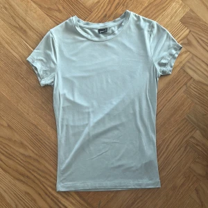 Ljusgrön soft touch t-shirt från Gina Tricot - En soft touch ljusgrön t-shirt från Gina Tricot i storlek S. Modellen är klassisk med rund halsringning och korta ärmar. T-shirten är i mjuk bomull och har en slim passform som sitter snyggt på kroppen. Säljer den för att den inte kommer till användning. Har använt den cirka 5 ggr.😊