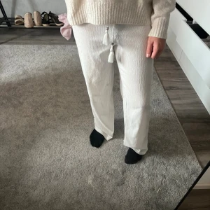Vita linnebyxor med snörning - Säljer ett par fräscha vita linnebyxor med snörning och tofsar i midjan. Byxorna har en rak och loose passform, perfekt för en chill och stilren look. Materialet är linne och de har en skön, avslappnad vibe. Även en fleck på inne benet men inget man tänker på