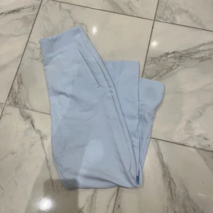 Ljusblå kostymbyxor från Zara - Snygga ljusblå kostymbyxor från Zara i storlek M. Byxorna har raka ben, diskreta fickor och är tillverkade i ett mjukt tyg som ger en clean och fräsch look. Perfekt för dig som gillar stilrena och moderna vibes.