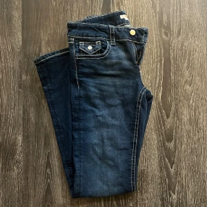 Mörkblå jeans från Gina Tricot - Säljer mina  mörkblå jeans från Gina Tricot young med kontrasterande vita sömmar. Byxorna har snygga detaljer som knappar på bakfickorna. Perfekta för dig som gillar en enkel men stilren look. Säljer dessa pågrund av att de inte längre kommer till användning och de ser ut att vara nya. Dom är i storlek 164 och jag är 163 lång och de passar bra i längden. Skriv vid intresse eller flera bilder💕