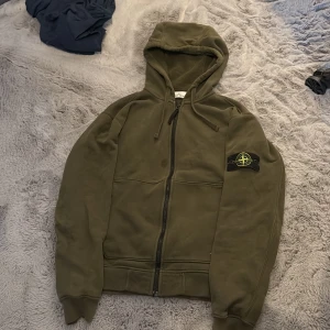 STONE ISLAND HODDIE - En väldigt snygg och stilren grön stone island hoddie. Fläcken som är på bilden är för att jag har handtvättat den med vanish på små fläckar ( kom privat om ni vill ha bilder utan fläcken, måste bara låta de torka ) Storlek S