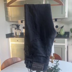 Svarta jeans från Jacob Cohen - Snygga svarta jeans från Jacob Cohen med klassisk femficksdesign och tydlig logopatch bak. Jeansen har raka ben och är tillverkade i ett mjukt denimtyg som ger en skön känsla. Perfekta för dig som gillar stilrena och tidlösa plagg.