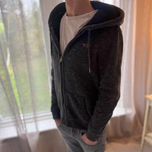 Hollister fodrad hoddie - Holister hoddie som är grå med svart päls på insidan. Storleken är S📏 Hoddien är i mycketbra skick 9/10🌟 Modellen är 177cm och väger 65kg📏 Skriv gör mer info🌟