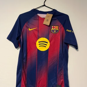 FC Barcelona matchtröja  - Säljer en FC Barcelona matchtröja från Nike i storlek S. Tröjan har klassiska blå och röda vertikala ränder, gult Spotify-tryck på bröstet och klubbmärke broderat. Tillverkad i lätt Dri-FIT polyester som andas, perfekt för fotboll eller häng med polarna. 