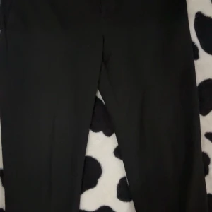 Svarta kostymbyxor med rak passform - Snygga svarta kostymbyxor med rak siluett och klassisk look. Perfekta för dig som gillar stilrena och enkla plagg. Byxorna har en smal midja och är gjorda i ett mjukt material som ger en skön känsla hela dagen.