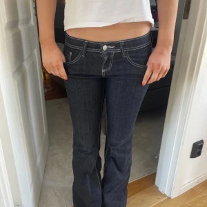 Mörkblå bootcut jeans med låg midja - jätte fina mörkblåa jeans med  vita sömmar. Endast använda en gång så de är i helt nytt skick💞