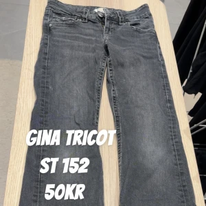 Mörkgrå jeans från Gina Tricot st 152 - Snygga mörkgrå jeans från Gina Tricot i rak modell. Klassisk femficksdesign med knappar på bakfickorna och normal passform. Perfekta till en avslappnad stil och tillverkade i mjukt jeanstyg.