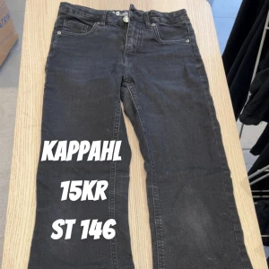 Svarta jeans från Kappahl stl 146 - Svarta jeans från Kappahl i klassisk femficksmodell. Jeansen har raka ben och normal passform, tillverkade i mjukt denimtyg med lätt stretch för extra komfort. Perfekta för en avslappnad och stilren look.