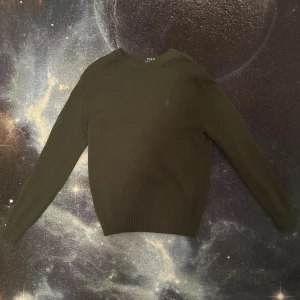 Mörkgrön stickad tröja Polo Ralph Lauren - Mörkgrön stickad tröja från Polo Ralph Lauren med logga på bröstet. Tröjan har ribbade muddar vid ärmslut och nederkant. Helt ny och oanvänd. Fraktas inom 24 timmar efter köp🚛📦
