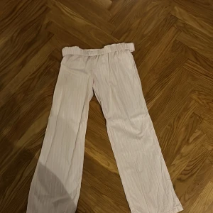 Ljusrosa linnebyxor från Gina - Säljer ett par ljusrosa, vit randiga linnebyxor med bred resår i midjan och raka, vida ben. Byxorna har fickor i sidorna. Linnebyxorna är i storleken 158/164. Resåren går att vika ned för att få extrem low waist. Säljer pga dom kommer inte till användning. Använda cirka 3ggr. 😊❣️