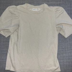 Glittrig beige topp/tshirt - Superfin beige topp från Kappahl med glittrigt tyg och puffiga ärmar. Perfekt vardaglig tröja med det lilla extra eller nyår!⭐️