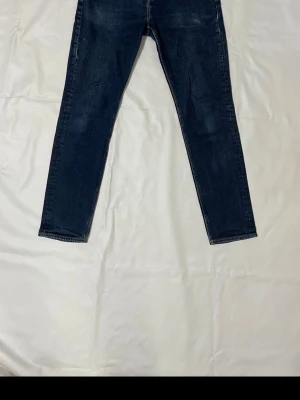 Slim fit jeans från H&M, blå 32/32 - Slim fit jeans från H&M i mörkblå tvätt, klassisk femficksmodell med smal passform och raka ben. Tillverkade i jeansmaterial med snygga kontrastsömmar. Perfekta för dig som gillar en stilren och modern look.