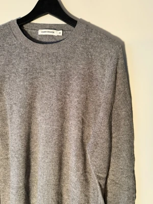 Grå stickad tröja Carin Wester - Säljer en enkel och stilren grå stickad tröja från Carin Wester i storlek M. Tröjan har rund halsringning och långa ärmar, väldigt skön!