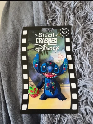 Stitch Crashes Disney Jumbo Pin 8 - Snow White - Unik samlarpin från Stitch Crashes Disney nummer 8 av 12 - Snövit och dom sju dvärgarna. Pin:en föreställer Stitch i blått med färgglada blommiga detaljer, där Stitch håller i det förgiftade äpplet.  Perfekt för Disney-fans som vill ha något speciellt i sin samling. I orgenalförpackning. Priset är högre då detta är ett samlarobjekt.