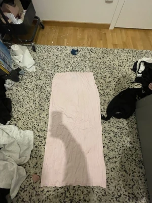 Ljusrosa långkjol från 157 - Säljer en enkel och stilren ljusrosa långkjol från 157 i storlek S. Kjolen har rak passform och är gjord i ett mjukt material som känns skönt mot huden. Perfekt att matcha med en crop top eller hoodie för en chill look. Lite smutsig dock men tvättas bort helt