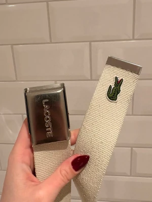 Lacoste bälte i vit och blå - Två Lacoste bälten, ett i vitt och ett i mörkblått. Båda har tecken på användning men varit sparsamt använda. Nypris 500kr/styck. 2st säljs för 500kr, eventuellt 250kr styckvis. 105cm långt. Original förpackning tillkommer. 