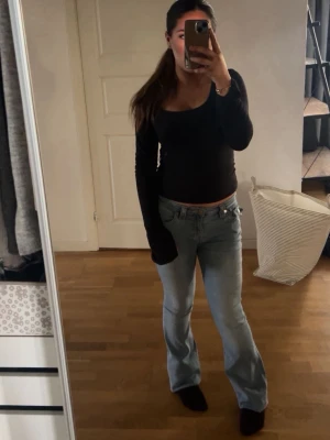 Ljusblå bootcut jeans från True Religion  - Säljer ett par ljusblå True religion jeans med bootcut-modell och klassisk femficksdesign. Jeansen har mid midja och är tillverkade i mjukt denimtyg. Perfekta för dig som gillar en avslappnad och trendig look. Bra skick! Stolek 26