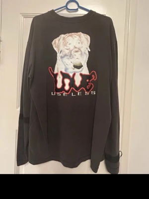 Sad boys tröja Yung Lean - Cool mörk grå långärmad tröja från SAD BOYS GEAR i storlek medium. Baksidan har ett stort tryck med en hund och texten 'sadboys', framsidan har ett rött skruv-motiv. Tröjan har rund hals och detaljer med band på ärmarna. Perfekt för dig som gillar streetwear och unika prints.