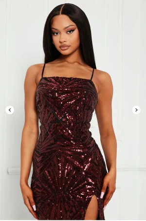 Fashionnova balklänning XS - Supersnygg burgundy långklänning med paljetter och tunna axelband. Klänningen har figurnära passform och en hög slits på ena sidan. Ger kroppen en form och sitter som en smäck. Helt ny och oanvänd (i prislappen).
