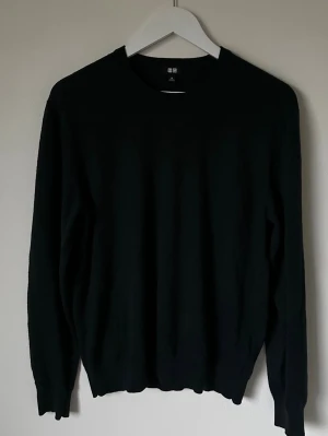 Mörkgrön stickad tröja från Uniqlo - Mörkgrön stickad tröja från Uniqlo i storlek M. Tröjan har rund hals, långärmad design och är tillverkad i 100% ull vilket gör den både mjuk och varm. Perfekt för kyliga dagar och enkel att matcha med olika outfits. 5L7