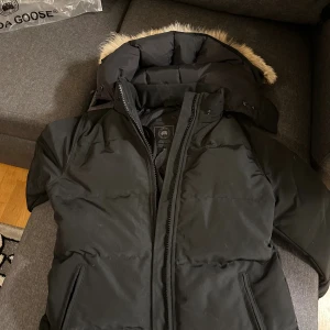 Canada Goose Dam  - Säljer en svart dunjacka från Canada Goose med fluffig päls på huvan.  Helt nytt oanvänd jacka felfritt säljer pga fel storlek passar för dem S/M liten i storleken 