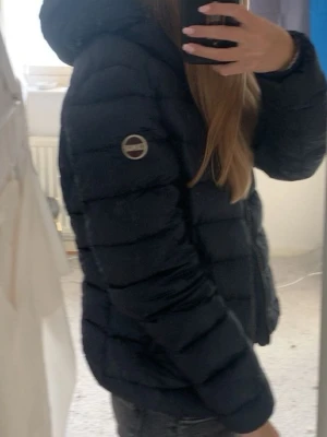 Svart pufferjacka från Colmar - Intressekoll på min Colmarjacka. Märket har blivit lite slitet under tiden jag haft jackan och ena blixtlåset till jackfickan funkar inte. Pris kan diskuteras 