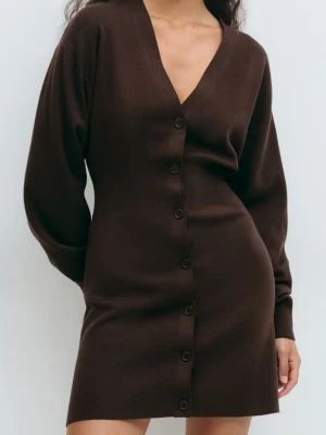 Knitted button down dress - Snygg brun stickad kortklänning med v-ringning och långa ärmar. Klänningen har knappar hela vägen framtill och en figurnära passform som framhäver siluetten. Perfekt för dig som gillar stilrena och enkla plagg med en twist.