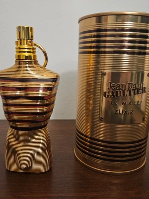 Jean Paul Gaultier Le Male Elixir 75 ml - Jean Paul Gaultier / JPG Le Male Elixir. Saknar ca 5 ml, är högst upp på den översta genomskinliga biten. Full presentation.