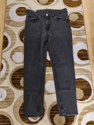 Svarta tapered jeans från H&M - Säljer ett par svarta jeans från H&M med tapered regular fit. Klassisk femficksmodell med knapp och dragkedja i midjan. Jeansen har en rak och något avsmalnande siluett, perfekt för dig som gillar en clean och enkel look.