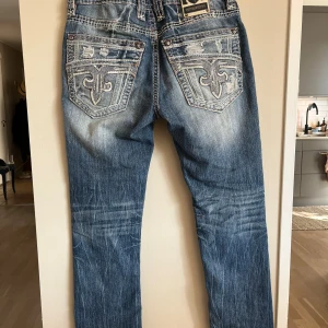 Rock Revival Jeans (SÄLLSYNTA!) - Säljer ett par feta jeans som jag köpte men har inte använt, har testat dom en gång. Märket på dem är Rock Revival och nypris är ca. 2500kr. Skick: 9/10 använda men ser nya ut, väldigt bra jeansmaterial. Passformen på dem är slim med lite bootcut. Sitter väldigt bra. Storlek 30/32 ungefär, står att de är 33 men skulle säga att de sitter som 30-31. Kan tänka mig gå ner lite grann i pris vid snabb affär.