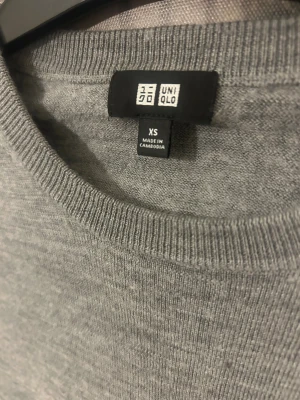 Grå merinoulltröja från Uniqlo XS - Säljer en stilren grå tröja från Uniqlo i mjuk merinoull. Tröjan har rund halsringning, lång ärm och en klassisk passform som funkar till allt. Perfekt för lager-på-lager under höst och vinter.