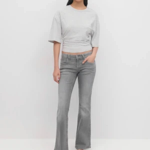 Grå bootcut jeans low waist - Snygga grå bootcut jeans från Perfect Jeans med låg midja och klassisk femficksdesign. Jeansen har en cool tvättad look, markerade sömmar och är tillverkade i mjukt denimtyg som sitter skönt. Perfekta för dig som gillar en trendig och avslappnad stil.