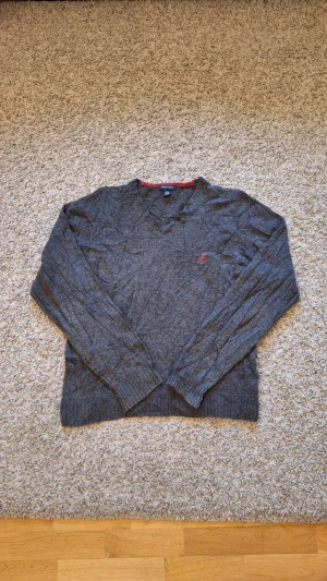Grå stickad tröja från Nautica - Varm skön grå stickad tröja från Nautica i storlek XL(passar L också). Använd fåtal gånger och skicket är i princip som ny, inga slitningar eller defekter finns. Den har dock lite creasningar då den har legat i lagret länge, men det går bort enkelt med lite strykning. Passar riktigt bra som en fin julpresent eller för dig som vill hålla dig varm och stilig under julen och vintern. Skick: 8/10