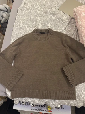 Brun stickad tröja Gina Tricot XS - Snygg brun stickad tröja från Gina Tricot i storlek XS. Tröjan har rund hals, ribbade muddar vid ärmslut och nederkant samt långärmad passform. Perfekt för dig som gillar enkla och stilrena plagg med chill vibe.