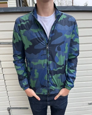 Woolrich windbreaker Camouflage  - Säljer en snygg vindjacka från Woolrich med blått och grönt camouflage-mönster. Skick 9/10 sjukt bra utan synliga defekter. Nypris ligger runt 3500kr men säljs nu för 899kr. Hör gärna av er vid minsta lilla fundering!