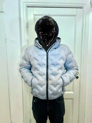 Polarblå Colmar pufferjacka med huva - Säljer en polarblå pufferjacka från Colmar med snygg quiltad design och huva. Jackan har dragkedja framtill, två sidofickor med dragkedja och Colmar-logga på ärmen. Perfekt för kalla dagar och riktigt stilren look.pris går att diskuteras!