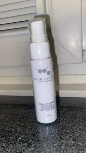 Hair Lab Argan Silk Spray 30ml - Argan Silk Spray från Hair Lab i en vit plastflaska med pump, 30 ml. Ger superglans, frizzkontroll och värmeskydd till håret. Perfekt för att få ett silkeslent och glansigt resultat.