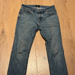 Neuw, Blå Lou Slim jeans, storlek 29/32 - Snygga blå jeans från Lou i modellen Slim Fit. Klassisk femficksdesign med normal midja och raka ben. Jeansen är tillverkade i slitstarkt denim och har subtila slitningar för en cool look. Perfekt passform för dig som gillar smalare jeans.  